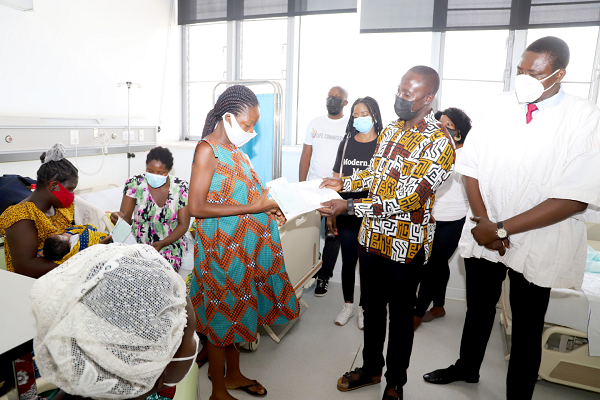 Mr Simon Awogbedek (2nd right), the Administrator of the Greater Accra Regional Hospital, presenting the cheques to Ms Doris Vondee (left), a beneficiary, who received them on behalf of the mothers at the maternity ward. Those with them include Dr Emmanuel Addipa-Adapoe (right), a Medical Officer at the Greater Accra Regional Hospital. Picture: GABRIEL AHIABOR