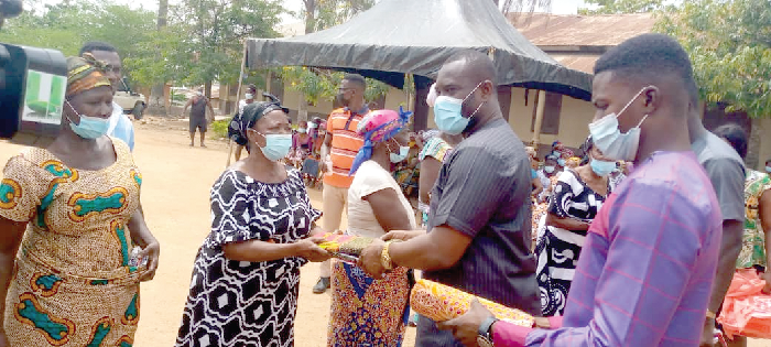 Mr John Kumah (2nd right) presenting the items to a beneficiary
