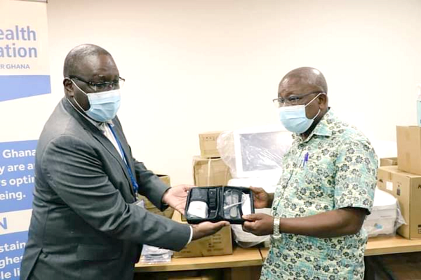Dr Francis Kaslo (left), WHO’s Country Representative, making a symbolic presentation to Mr Kwaku Agyemang-Manu, the Minister of Health