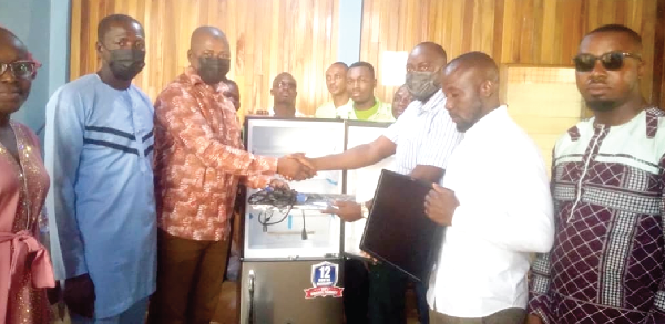 Alhaji Seidu Haruna (2nd left), MP for Wenchi, presenting a computer to Mr Abdul Samed, the Wenchi Municipal Commander of the Ghana Ambulance Service