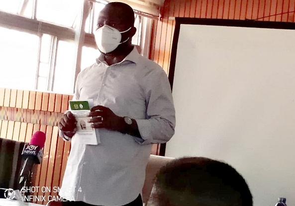  Mr Mohammed Adjei Sowah , the Metropolitan Chief Executive of Accra, launching the book while a section of the Public Toilet Owners and Operators within AMA  look on at the training