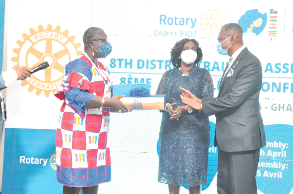 Mrs Georgina Theodora Wood (middle), former Chief Justice being presented with a gift by Ms Winfred Mensah (right), the Conference Chair, PDG, assisted by Nana Yaa Serebour (left), Past Assistant Governor