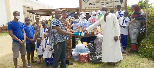 Mallam Abdallah Jibriel (right), the head of the Arabic school, presenting the items to ASP Narh David Tawiah (left), Commander in charge of Operations of the Koforidua Prison. Looking on are some inmates and students of the school