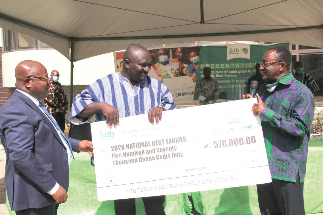 Dr Owusu Afriyie Akoto (right), the Minister of Food and Agriculture, presenting a dummy cheque to Mr Solomon Kwadwo Kusi, the 2020 National Best Framer, at a ceremony in Accra. Looking on is Dr John Kofi Mensah, MD, ADB