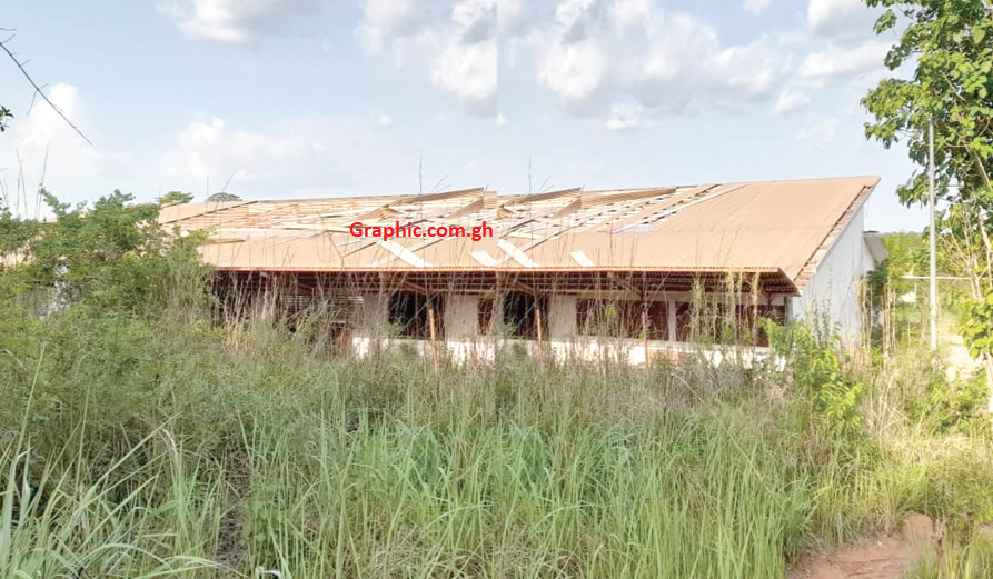 A building at the factory surrounded by weeds