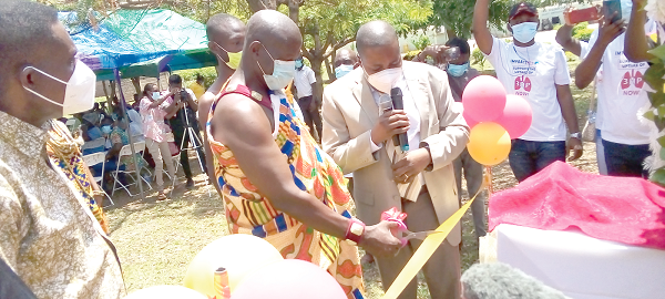  Nene Tettey Etti II, Asafoatse of Akwenor Mampong, being assisted by Dr Stephen Ayisi Addo, Programme Manager of the National AIDS/STI Control Programme, to cut the tape to launch the 3HP drug
