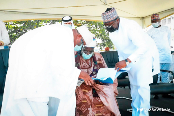 Dr Mahamudu Bawumia being assisted by Sheikh Mustapha Ibrahim (left), one of the muslim leaders, to show the building plan of the new mosque promised by the Vice-President to Sheikh Osman Nuhu Sharubutu, the National Chief Imam