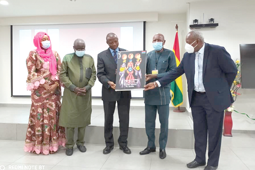 Alhaji Asei Mahama Seini (2nd right), Deputy Minister of Health, receiving a painting from Prof. Yankuba Kassama (3rd left), the leader of the Gambian delegation. Looking on are other members of the delegation