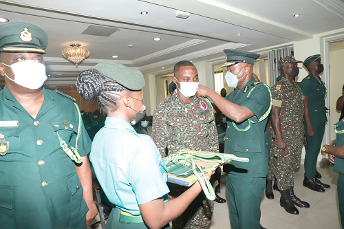 Mr Kwame Asuah Takyi (3rd right), Comptroller-General of the Ghana Immigration Service, decorating one of the officers with his new rank during the ceremony. Picture: EDNA SALVO-KOTEY
