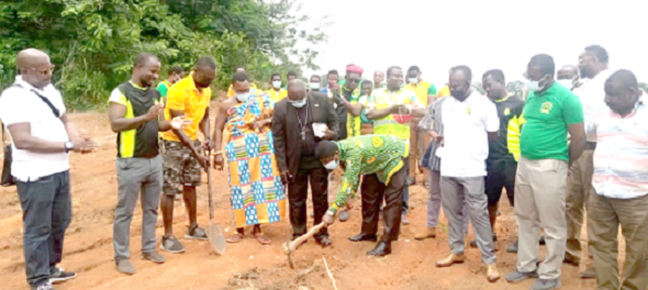 Mr Aaron Atuah Gyewu ( with pick axe) cutting the sod for the project to begin while some members of Amanfoo 97 and staff of the school look on