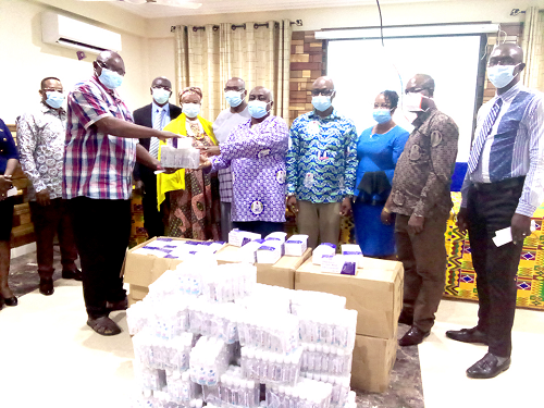 Mr Yussif Abubakari (left), Finance Officer, EI Africa Regional Office,  presenting some of the items to Mr Mark Dankyira Korankye, General Secretary of TEWU