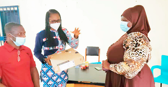 Ms Mildred Alexandra Menkiti (2nd left) presenting the item to Ms Zakia Issahaku (right)