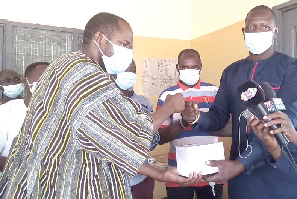 Mr Sampson Nambu (right), NPP Chairman of Yunyoo/Nansuan Constituency, presenting the items to Mr Abdul Rahaman, an official of Ghana Health Service. INSET: Some of the items