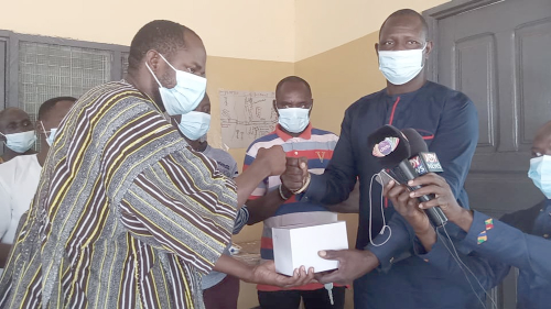 Mr Sampson Nambu (right), the NPP Yunyoo Constituency Chairman, presenting the items to Mr Abdul Rahaman, the District Health Director 