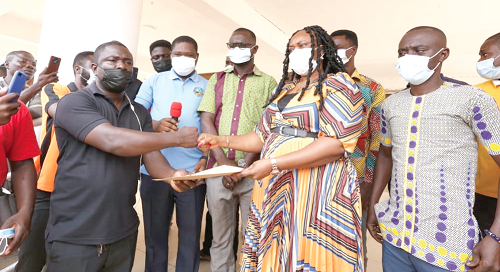 A member of the leadership of the Ada Youth Forum for Development presenting the petition to Ms Sarah Dugbakie Pobee, the District Chief Executive of Ada East