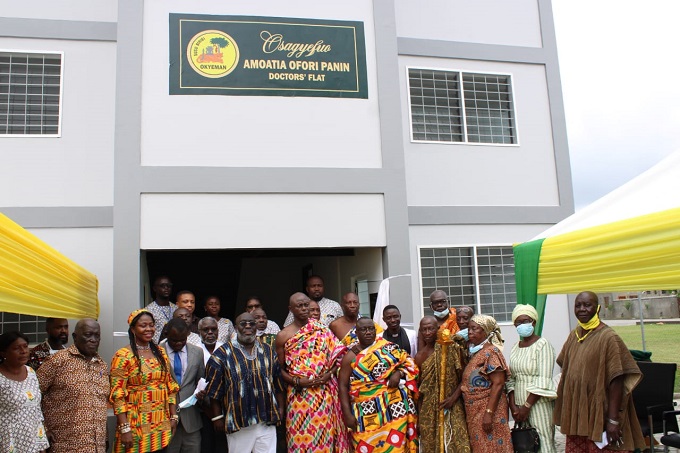 A group photograph of traditional authorities and hospital staff in front of the six-unit flat accommodation facility.