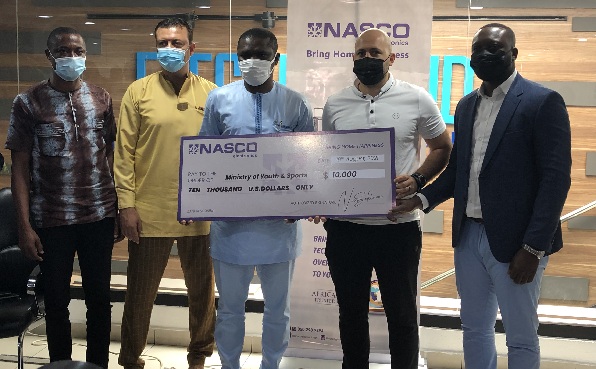 Mr Nour Sekloui (2nd right) presenting a dummy cheque to Mr Mustapha Ussif, Minister of Youth and Sports