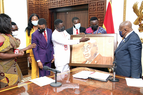 President Akufo-Addo receiving a portrait of himself from Mr Emmanuel Yiadom-Boakye (middle), President of NUGS.  Picture: SAMUEL TEI ADANO