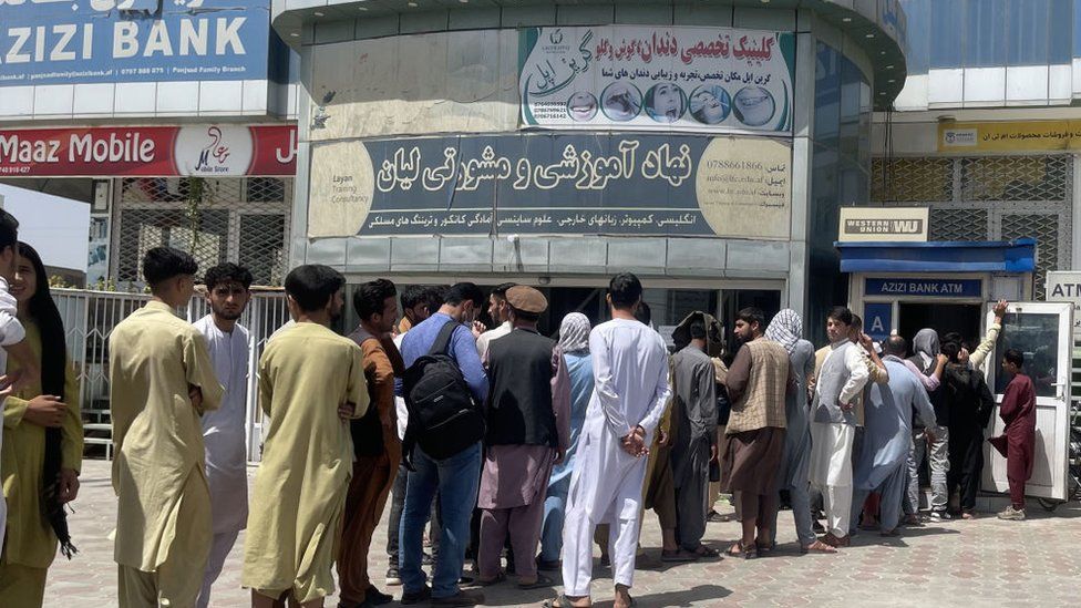 Afghan people line up outside AZIZI Bank to take out cash as the bank suffers amid money crises in Kabul