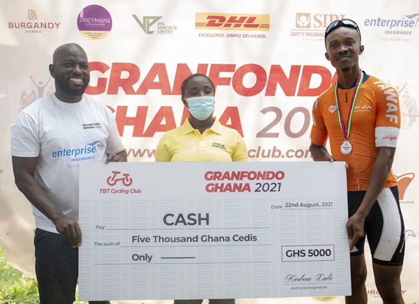 Victor Cudjoe, Gladiators Pro Cycling Club (far right) receiving his Cash Prize of GHS5,000. Also in the picture is Kwabena Larbi, Race Director (left) and Elizabeth Buchman of Sykes and Partners Ltd (middle) (PHOTO: Genic Images)