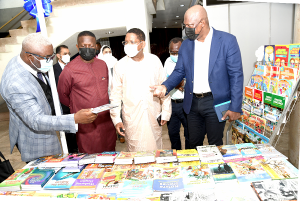 Mr Edward Yaw Udzu (left), Director, ALLGOOD BOOKS Limited, showing some books on exhibition to Mr Ato Afful (right), MD of the Graphic Communications Group Limited; Mr Diallo Abdourahamane (2nd right), Country Director of (UNESCO), and Dr Wale Okediran (3rd right), Secretary-General of PAWA, at the opening of the 18th Ghana International Book Fair.  Picture: EBOW HANSON