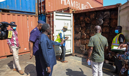 Mr Benito Owusu-Bio (2nd left), the Deputy Minister of Lands and Natural Resources in charge of Forestry, pointing at the  impounded  containers