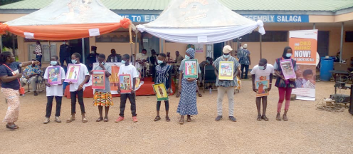 Some schoolchildren displaying posters on the campaign against child marriage and abuse at the meeting