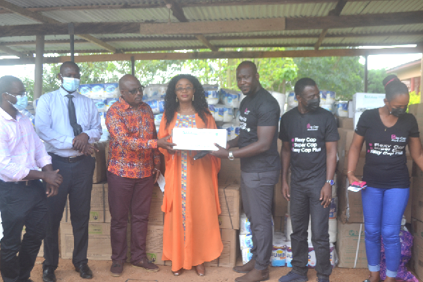 The Chief Executive Officer of Big Cap Micro Credit (Mr Fridaus Mubarak Yussif(3rd right) handing over one of the items to the MP for Agona West, Mrs Cynthia Morrison(4th left) while other officials look on