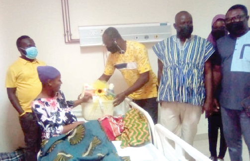 Mr. Kofi Owusu (middle), MTN Ghana, presenting some items to a mother at the Wa Regional Hospital