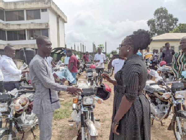 Mrs Felicia Amissah, District Chief Executive  for Assin South, handing over one of the motorbikes to Mr Aaron Owusu, the assembly member for Assin Edubiase.