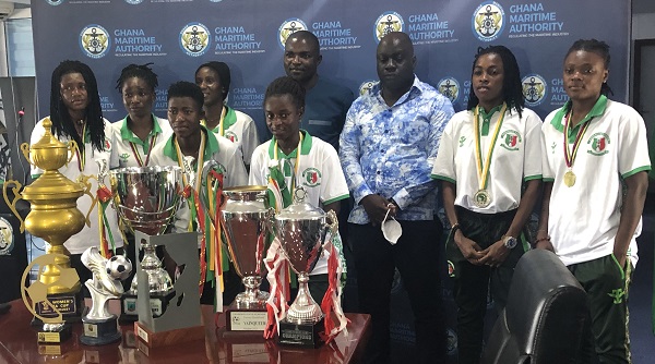 Some players and officials of hasaacas ladies with the trophies during the visit