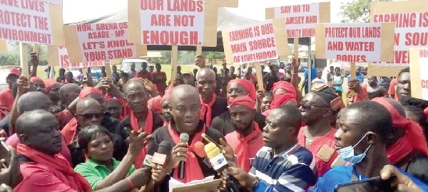 Mr Adade Wiredu (arrowed) with some of the demonstrators holding placards at the mining site at Asamang-Tamfoe 