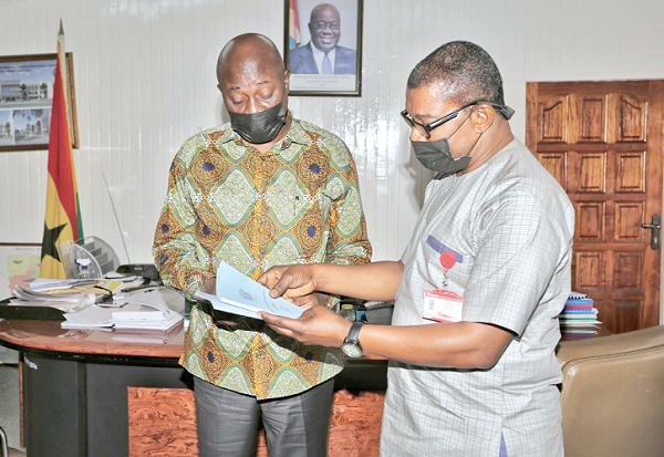Mr Dan Botwe (left), Minister of Local Government, presenting copies of the Local Governance Act, 2016 and the Registration of Births and Deaths Act, 2020 to Mr Kobby Asmah, Editor, Daily Graphic. Picture: DOUGLAS ANANE-FRIMPONG