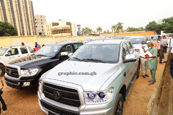 Mr Sulemana Sualuhu (with file), Internal Auditor of the NIA, and Mr Isaac Tetteh (2nd from left), acting Head of Procurement of the NIA, inspecting one of the vehicles. Pictures: Gabriel Ahiabor