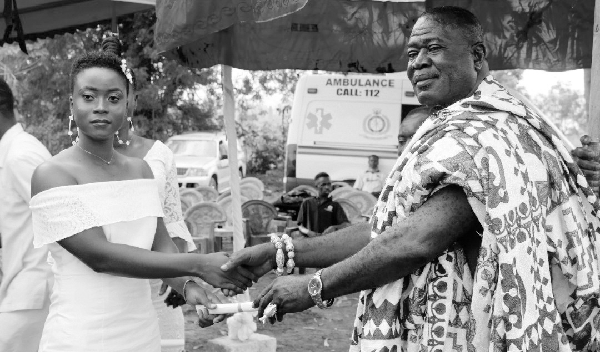 Nana Boakye Bonsu (right), the Akwamuhene of the Duayaw Nkwanta Traditional Area, presenting a certificate to a female graduand