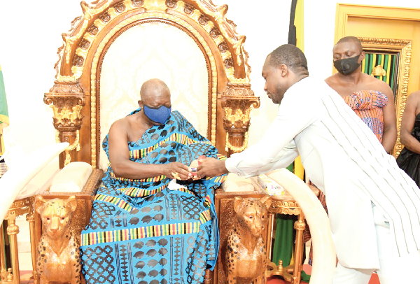 Mr Richard Adjei Mensah Ofori Atta (right) presenting the gold coin to Otumfuo Osei Tutu II