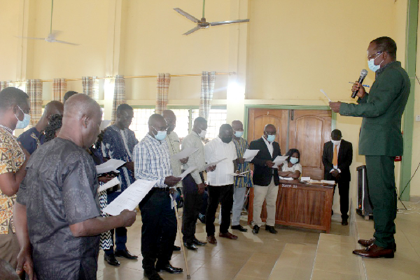  Mr Jacob A. Ntiamoah  (right), the Ahafo Regional Economic and Planning Officer, swearing in members of the Spatial Planning Committee