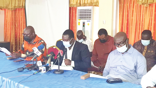 Mr Oheneba Kwasi Afawuah (holding microphone) addressing the press conference. Those with him are Mr Clement Boateng (right), Vice-President of GUTA; Mr Sampson Asaki Awingobit (left) of the Importers and Exporters Association as well as other members of the various groupings
