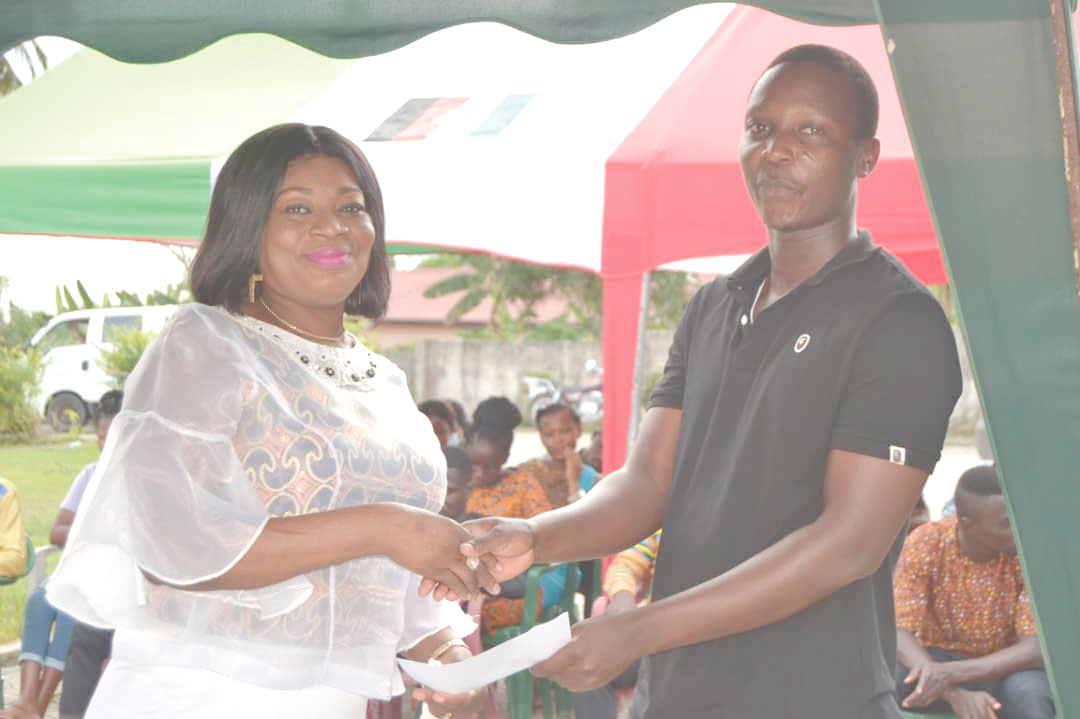 Mrs Pokuah Sawyerr (left) presenting GH¢1,000 to Mr Albert Ahwireng, a beneficiary, who is a student of the Odumase-Krobo Nursing and Midwifery Training College 