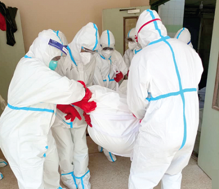 Environmental health workers moving the body of a covid-19 casualty for burial
