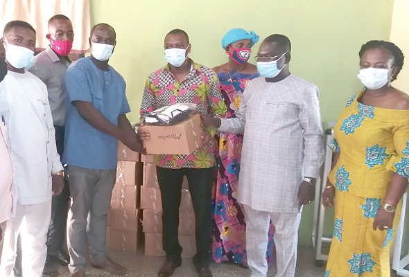 Dr Kingsley Nyarko (middle) presenting nose masks and sanitisers to Mr Samuel Gyasi, the Presiding Member for distribution to the residents of his electoral area