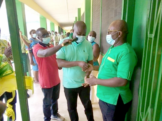  Mr Kingsley Ofosu Ntiamoah (middle) presenting the keys of the facility to Mr Emmanuel Poku-Sarkodee (right)