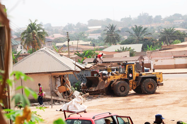 A bulldozer pulling down a structure at the washing bay