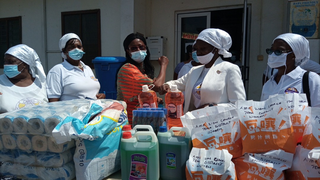 Mrs Cynthia Serwaa Dogbe (2nd right), the Missionary Supervisor of the Western West Africa Episcopal District of the A.M.E Zion Church presenting some of the items to Madam Matilda Akuaku (3rd left), a Senior Midwifery Officer. With them are some members of the group.