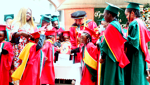 Dr Benedict Yartey (middle), Principal, British Colombia College, cutting the graduation cake with the graduates. Picture: Maxwell Ocloo