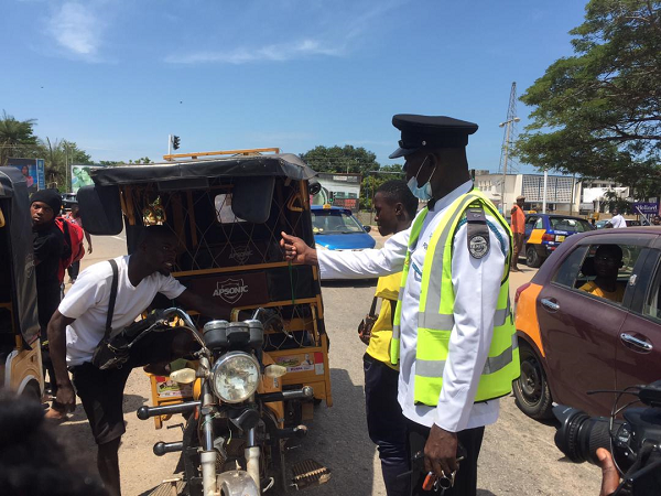  A tricycle rider being queried by a police officer on documents covering his vehicle