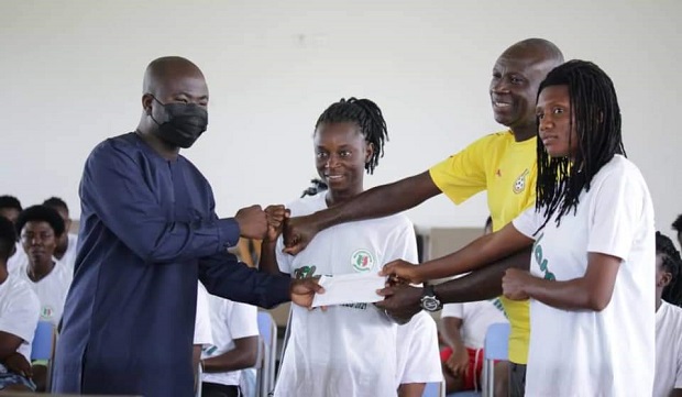 Tamimu Issah, an Aide of Vice President Dr. Mahamudu Bawumia, presents the cash to the team at their camping base in Prampram