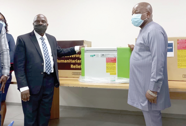 • Mr Bassy Antwi (left), the Manager in charge of Africa Special Project at the UPS, handing over one of the vaccine fridges to Mr Kwaku Agyeman- Manu, the Minister of Health 