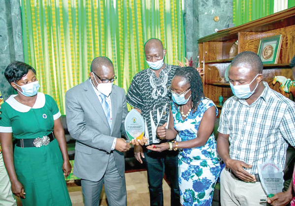 Ms Phoebe Balagmum, Nadowli-Kaleo District Director of Health Services (second right), presenting the shield to Mr Bagbin