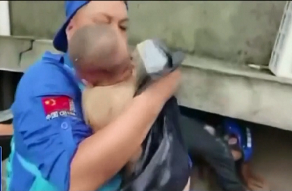 Chinese rescuers pull out a baby trapped under rubble after floods